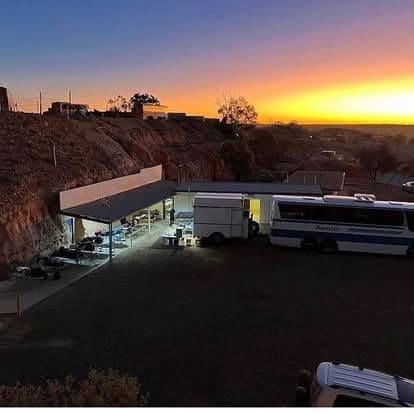 Chef Skills Catering kitchen and tour bus parked on an outback bluff under a vivid sunset.